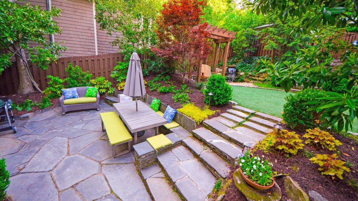 stone backyard patio living space with colorful landscaping