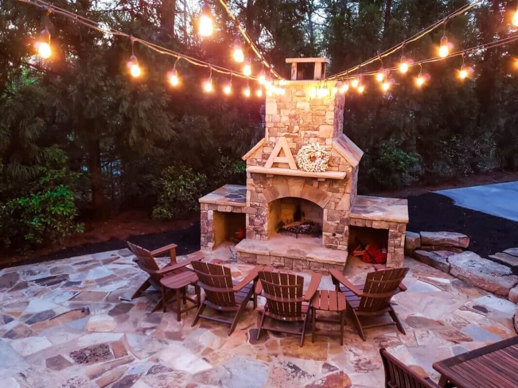 outdoor fireplace with string lights and seating