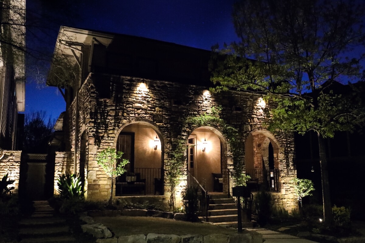stone house with exterior surface lighting and front porch