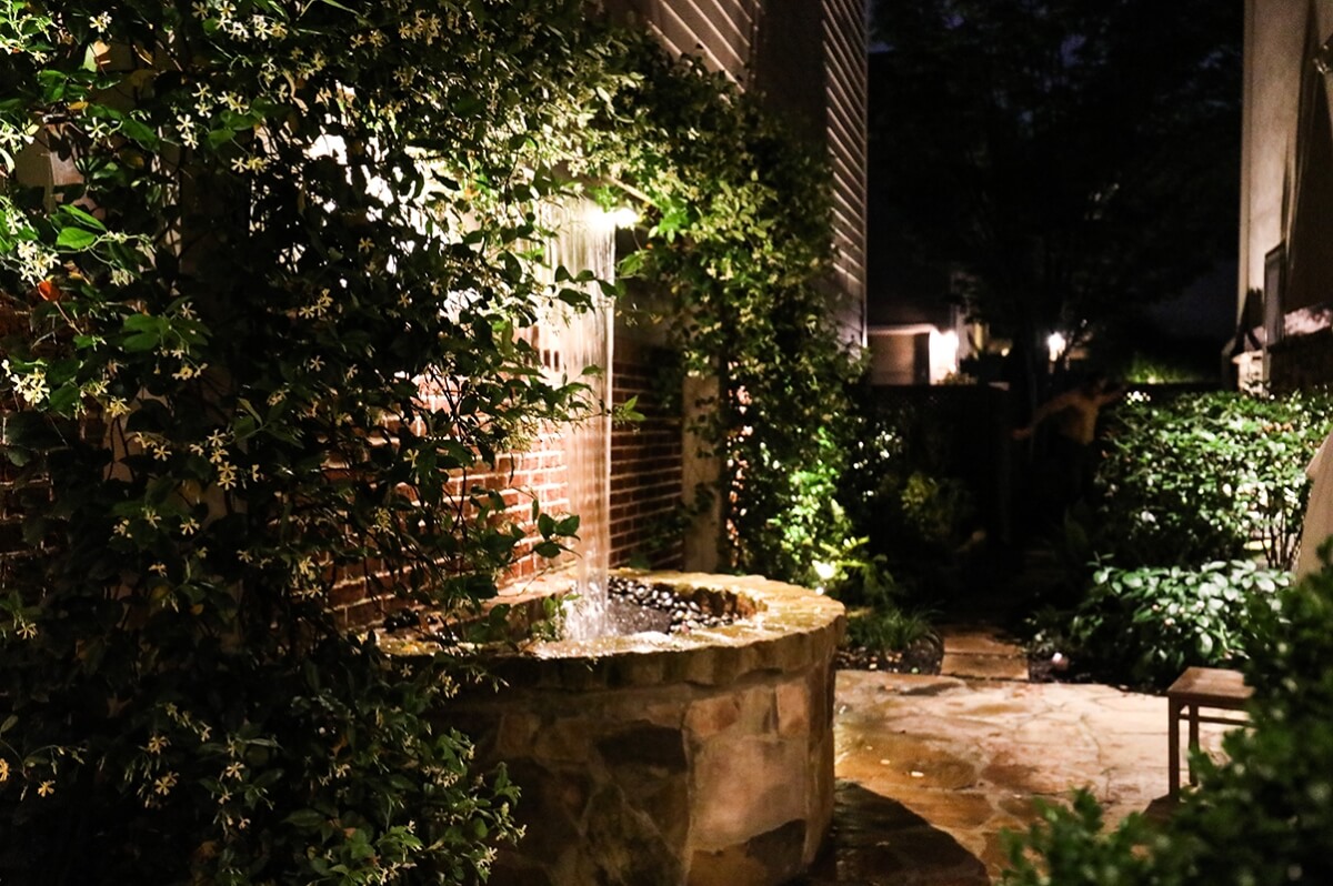 water fountain with vines growing in backyard living area