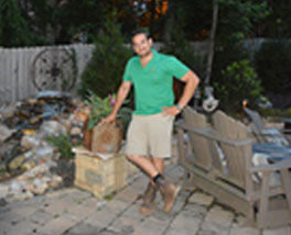 proud designer for Outdoor Makeover & Living Spaces in green shirt on backyard makeover project