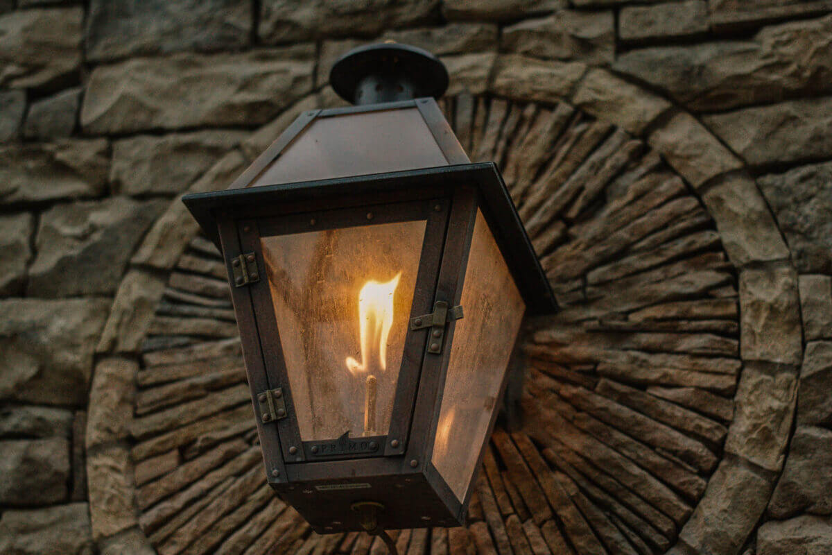outdoor gas burning light fixture mounted on stone wall