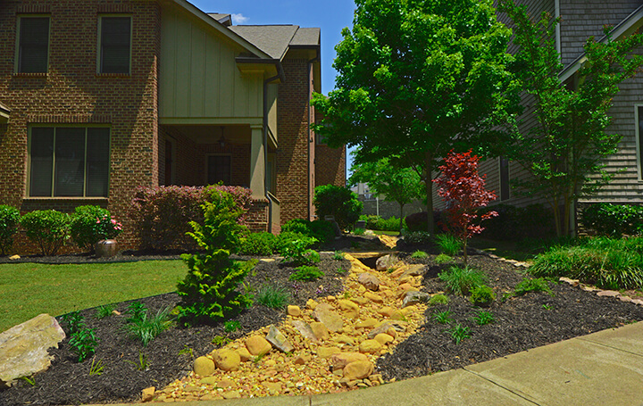 front yard with stone landscape drainage design