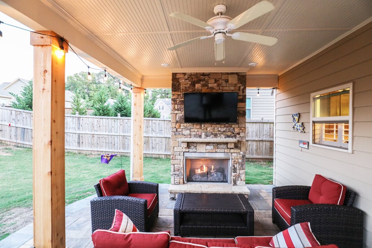 backyard outdoor living room with furniture, fan, and fireplace