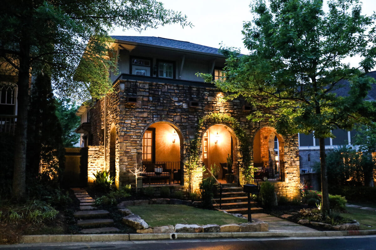 outdoor lighting on stone house with landscaping