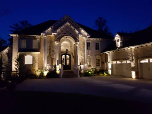 large stone house with outdoor lighting design at night
