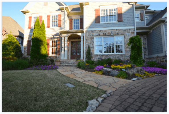 stone walkway leading to house with colorful flowers and hardscaping