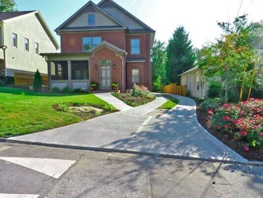 front yard landscaping design with driveway leading to brick house